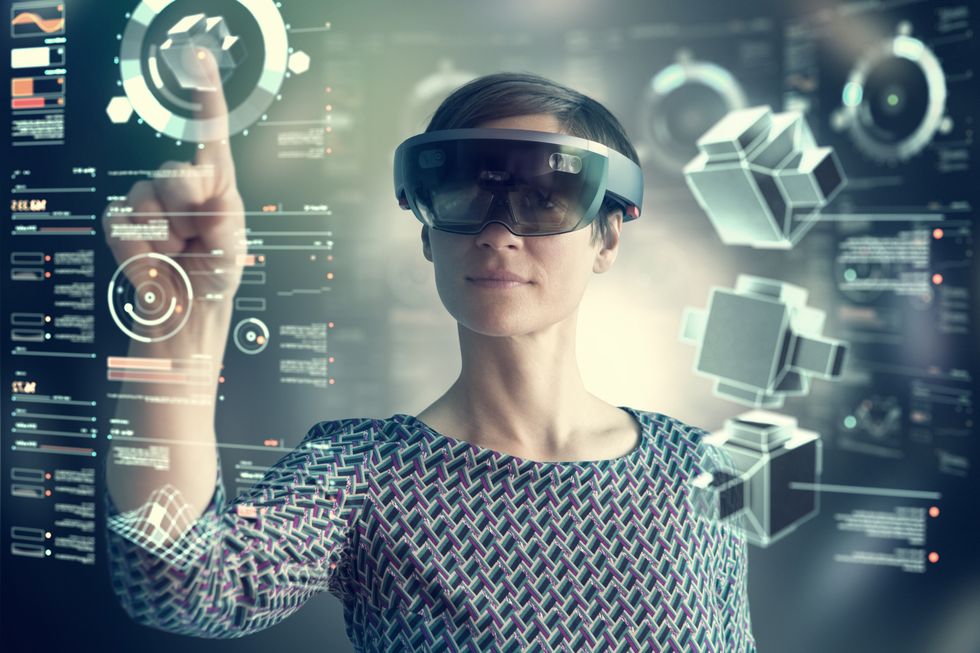 mujer con gafas inteligentes de realidad mixta tocando una pantalla transparente